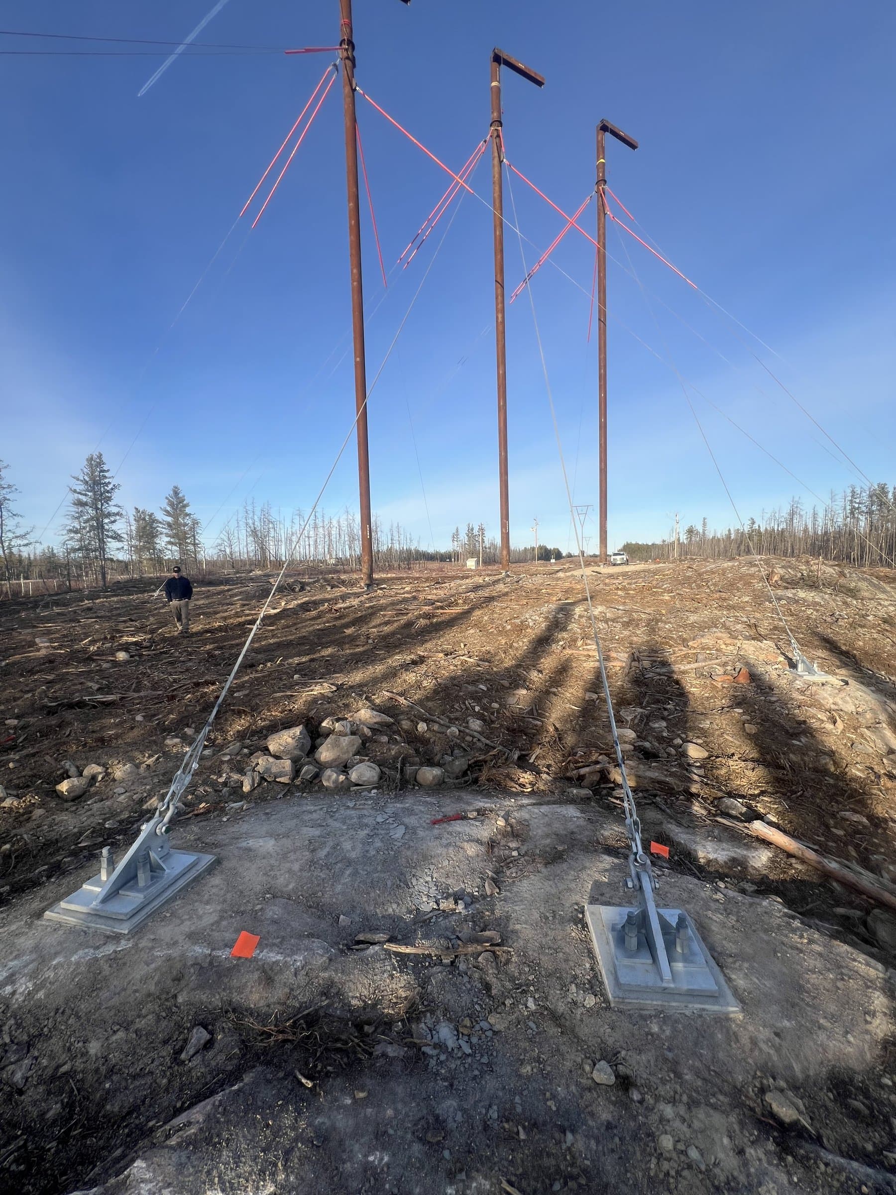 Guy-wire anchor plates secured after grouting on a transmission corridor
